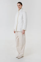 White DELEGAN jacket worn side view, stylish outerwear with a clean, modern design, perfect for casual or layered outfits.