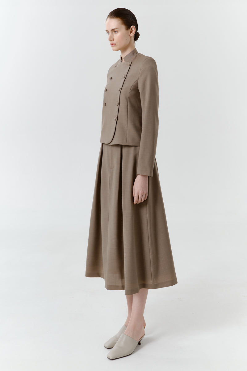 Worn side view of DELEGAN wool midi skirt showcasing its tailored fit and classic design in a neutral color.