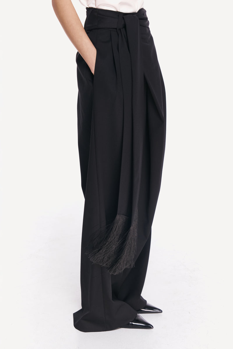 DELEGAN BAKHROMA pants shown from the side, featuring a relaxed fit with detailed stitching and comfortable fabric.