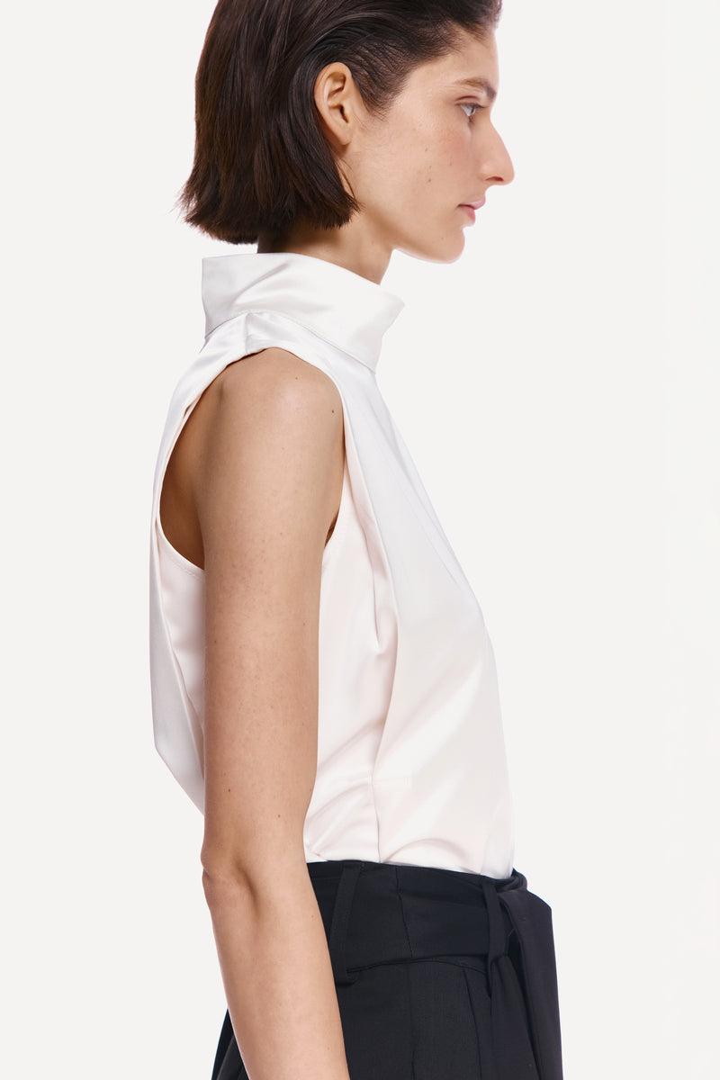 Delegen pearl silk high neck top displayed on a mannequin, featuring a sleek design and elegant high neckline.