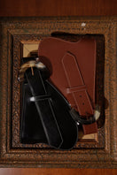 Brown leather belt from Adriana Castro's La Jefa collection featuring a sleek, polished design and a silver buckle.