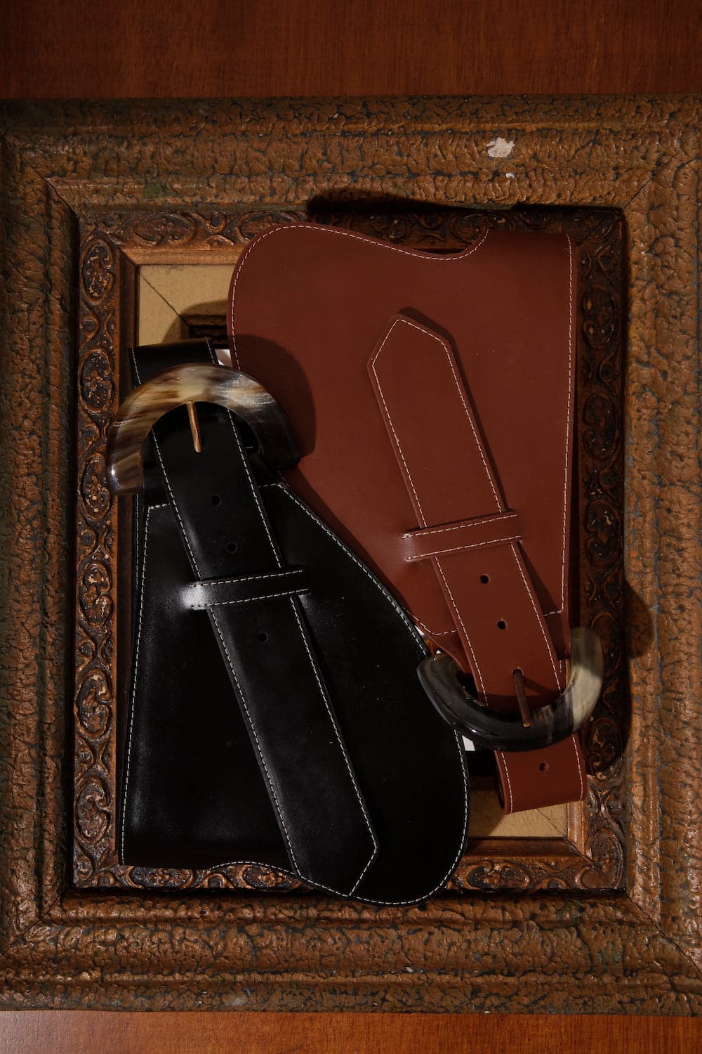 Brown leather belt from Adriana Castro's La Jefa collection featuring a sleek, polished design and a silver buckle.