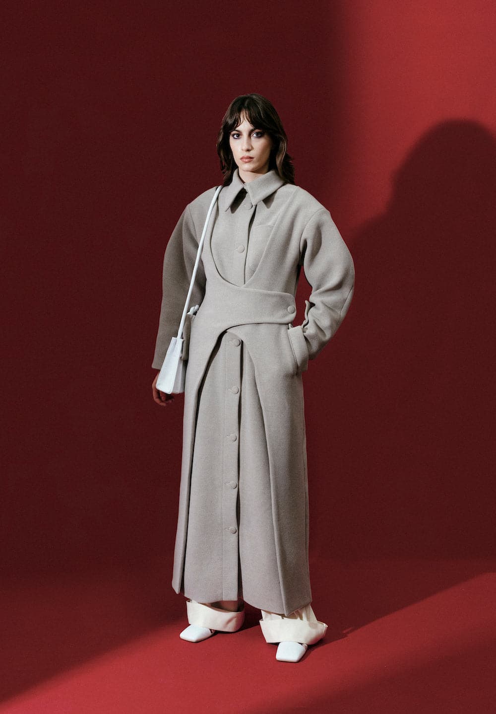 Gray asymmetric wool-blend coat by Blikvanger, featuring a modern design and tailored fit, shown on a model.