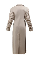 Beige crumple-sleeve trench coat by Blikvanger, shown in a close-up with textured fabric and stylish design details.