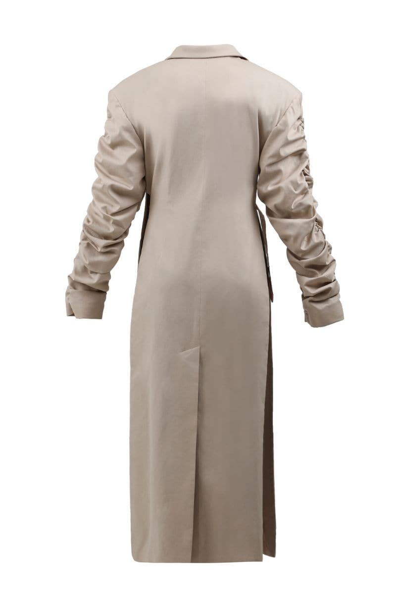 Beige crumple-sleeve trench coat by Blikvanger, shown in a close-up with textured fabric and stylish design details.