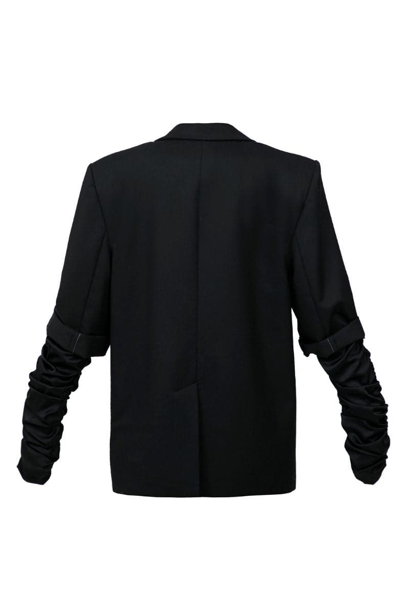 Black crumple-sleeve long blazer by Blikvanger, shown on a mannequin, with tailored fit and classic lapel design.