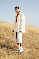 Crumple-sleeve long white blazer by Blikvanger, tailored fit with stylish sleeve design, displayed on a white background.