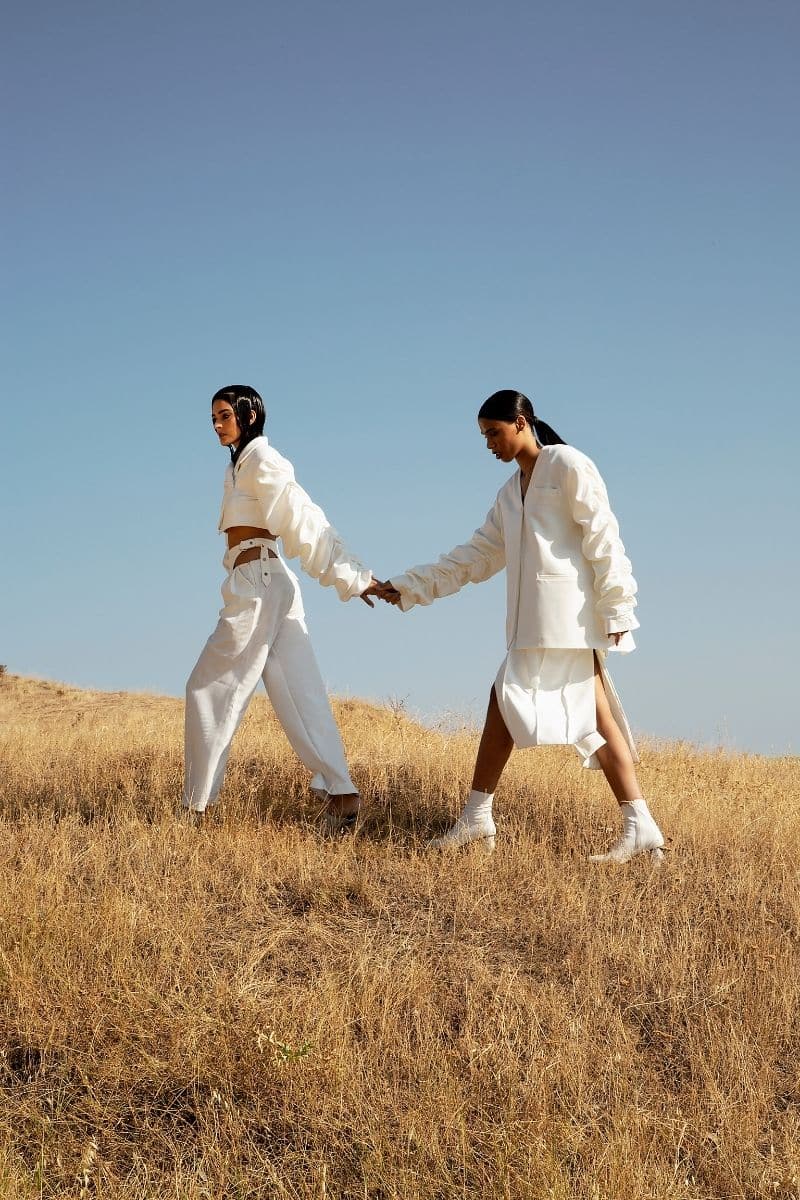 Crumple-sleeve long white blazer by Blikvanger, tailored fit, with textured fabric and classic lapel, shown on a model.