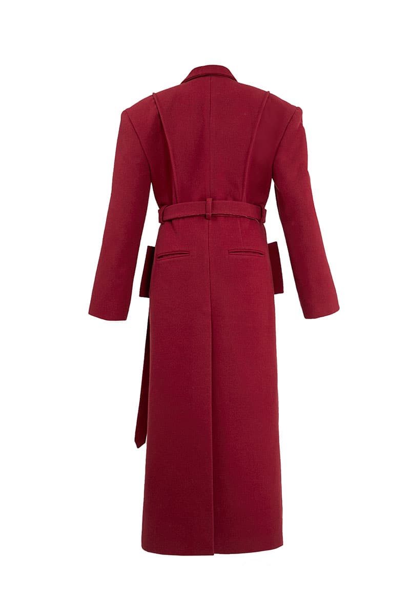 Full-length maroon coat by Blikvanger, structured design with tailored fit, displayed on a hanger against a neutral background.