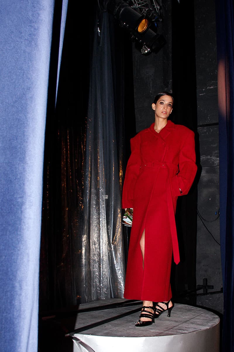 Full-length maroon coat by Blikvanger featuring structured design and tailored fit, shown on a model.