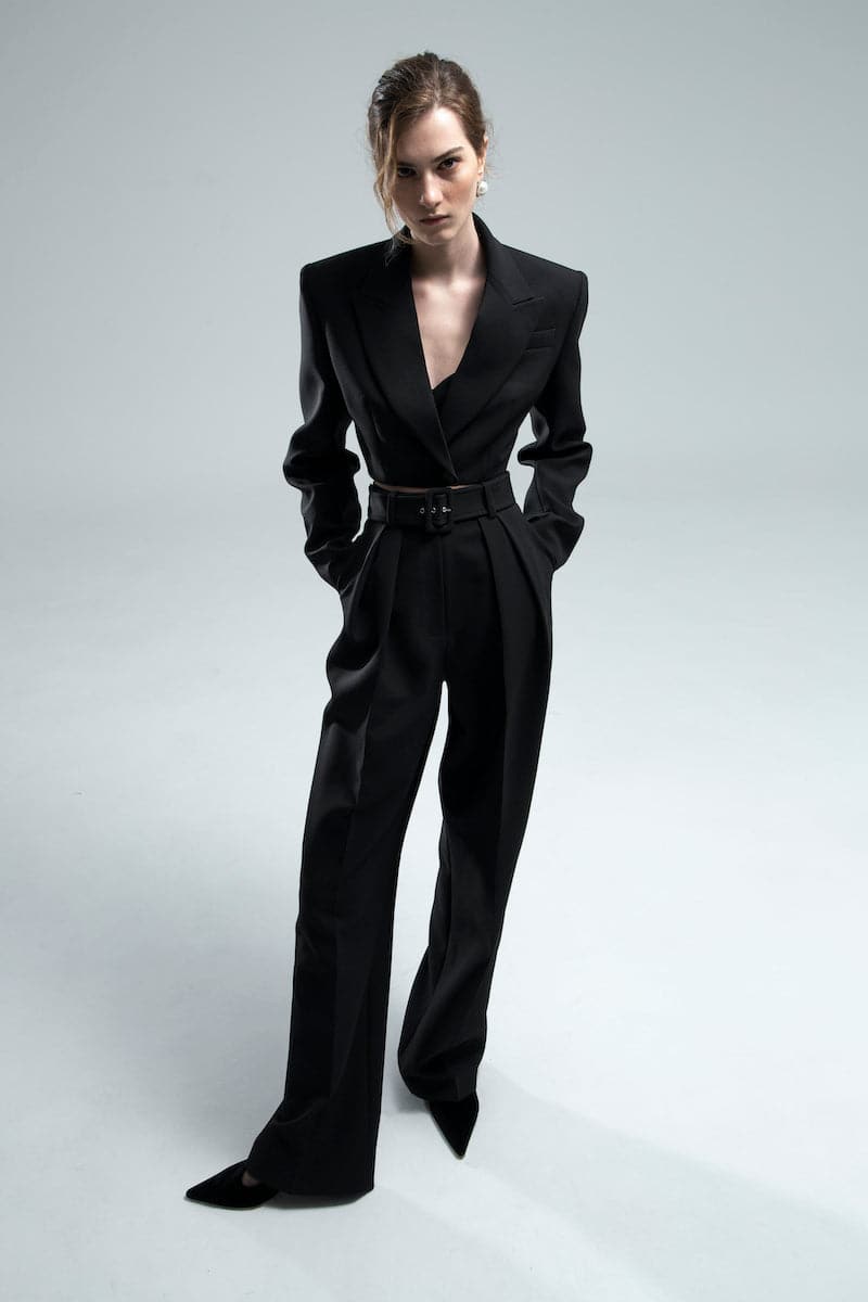 Black Dalood Greta Cropped Blazer displayed on a hanger, showcasing its tailored fit and sleek design.