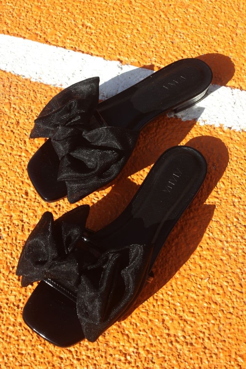 Black patent bow sliders by House of Atana, stylish flat sandals with bow embellishment, perfect for casual and chic summer looks.