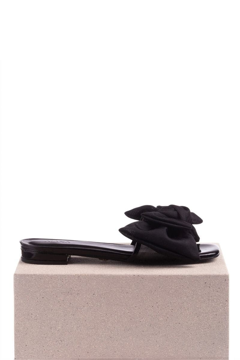 Black patent bow sliders by House of Atana featuring a sleek flat design and stylish bow detail on the top.
