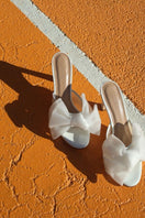 White patent bow mules, House of Atana sandals with sleek design and stylish bow detail, perfect for casual or dressy occasions.