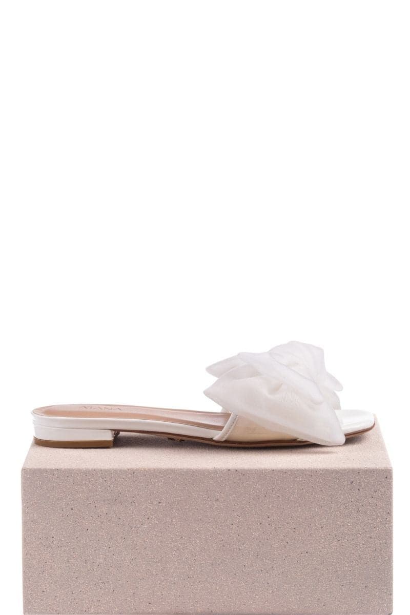 White patent bow slides flats by House of Atana, featuring a sleek design with a stylish bow detail and comfortable flat sole.