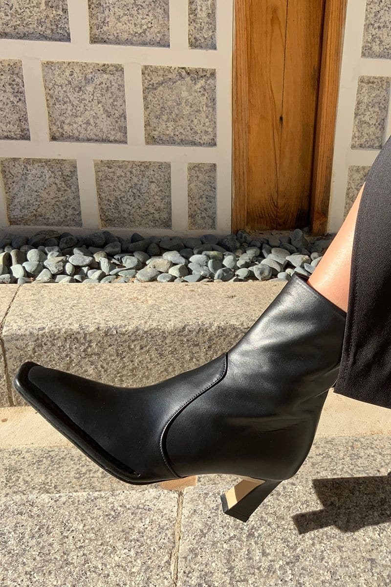 Je La Connais Calais black ankle boots with a sleek design and low heel, displayed on a neutral background.