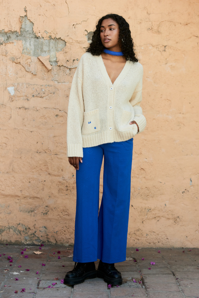 Cream knitted cardigan by La Granni, featuring a cozy knit design, long sleeves, and button closure, perfect for casual wear.