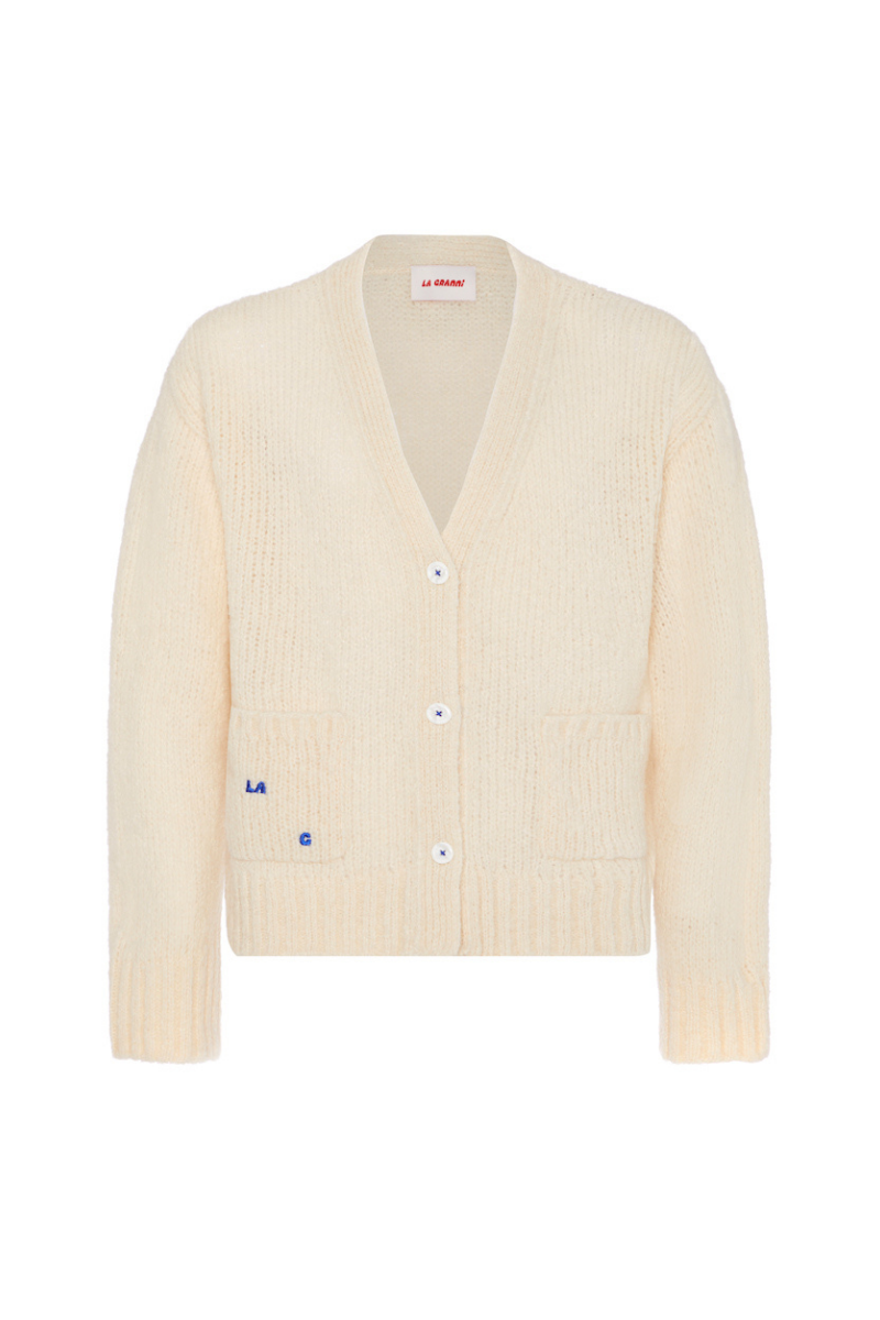 Cream knitted cardigan by La Granni, featuring a cozy, textured design, displayed on a hanger with a soft background.