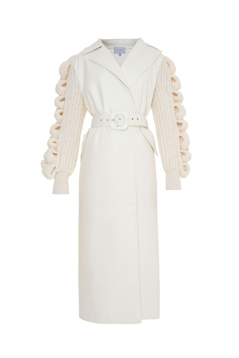Liya white faux leather coat with knitted sleeves, stylish winter outerwear, full view of the modern coat on a model.