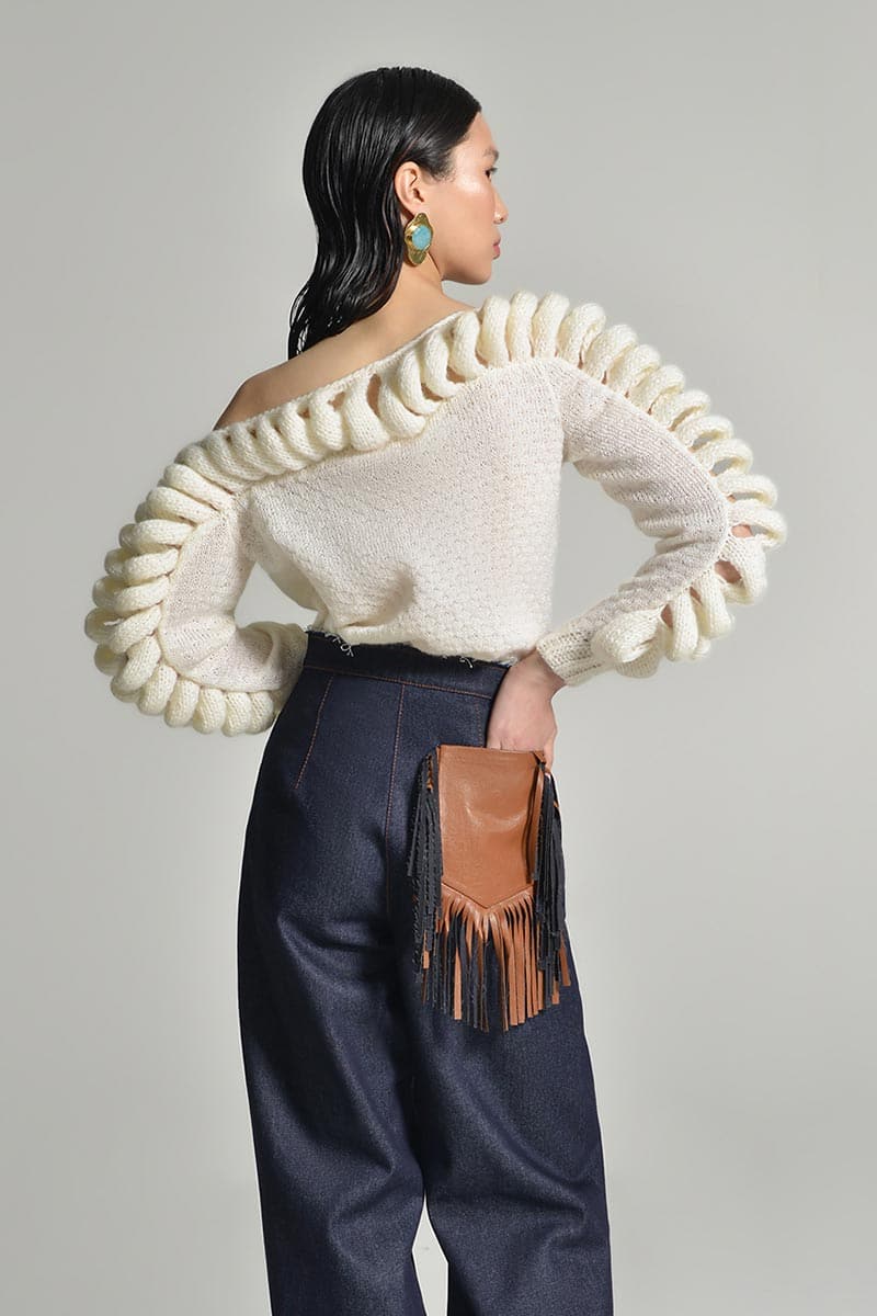White Liya off-shoulder knit sweater with a cozy, relaxed fit, featuring a stylish off-shoulder design and long sleeves.