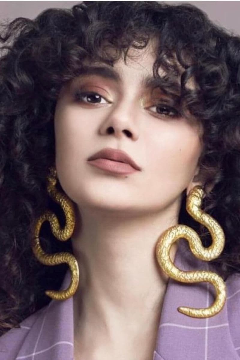 Gold-plated snake-shaped earrings from Natia x Lako, showcasing a bold and elegant jewelry design in the image.