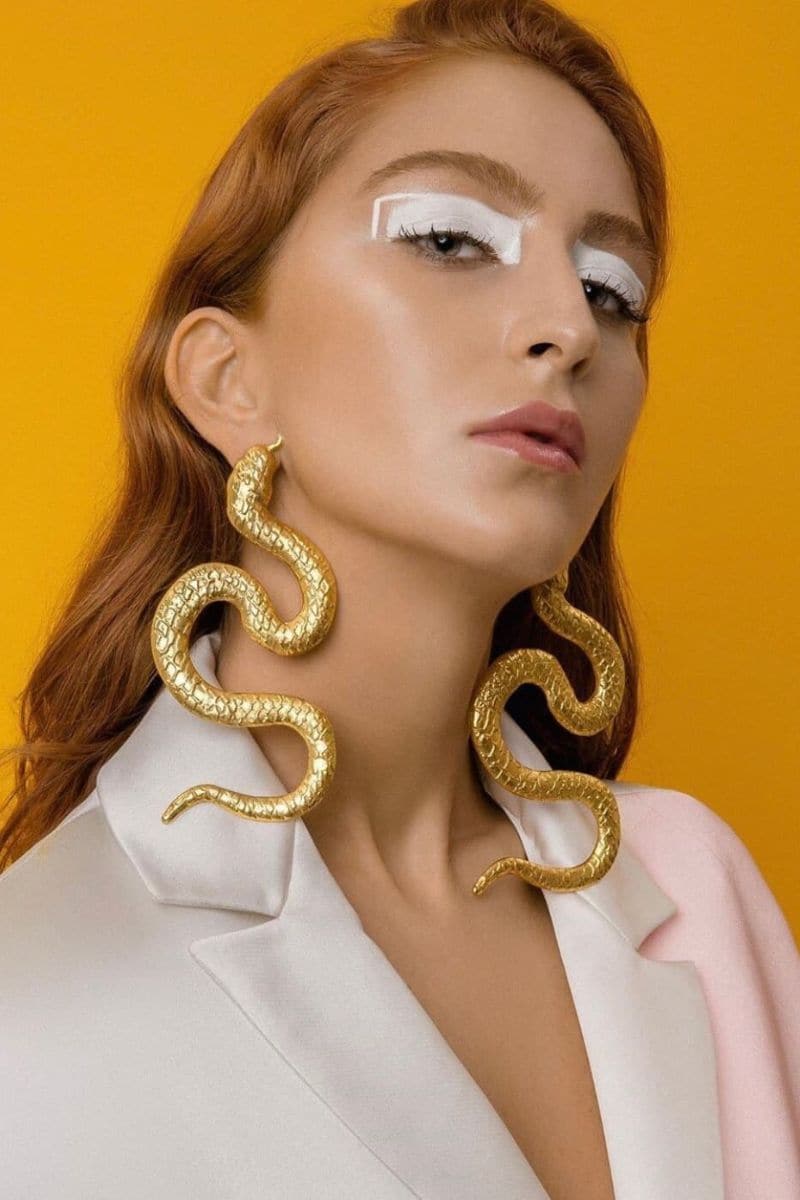 Gold-plated snake-shaped earrings from Natia x Lako, featuring bold, intricate design perfect for statement jewelry.