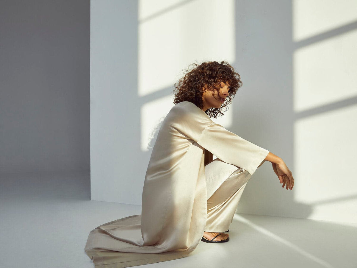 Oyster silk midi kimono robe by Silked, featuring a flowing design with long sleeves and elegant lapel, displayed on a hanger.