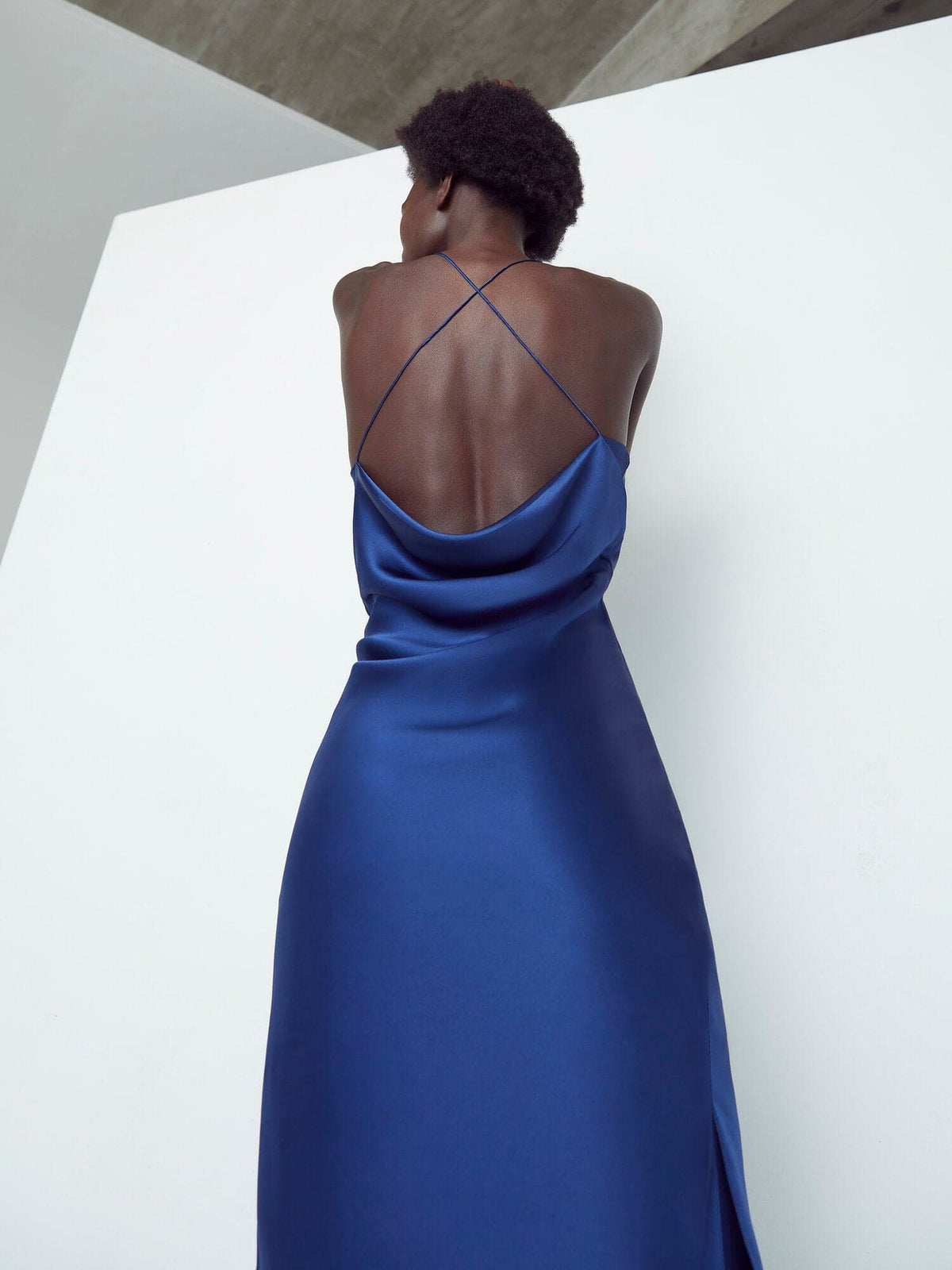 Sapphire Silked silk midi slip dress on a mannequin, showcasing smooth fabric, V-neckline, and sleek midi length.