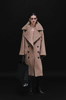 Vaska double-breasted relaxed coat in caramel color, shown on a model, featuring a classic collar and tailored fit.