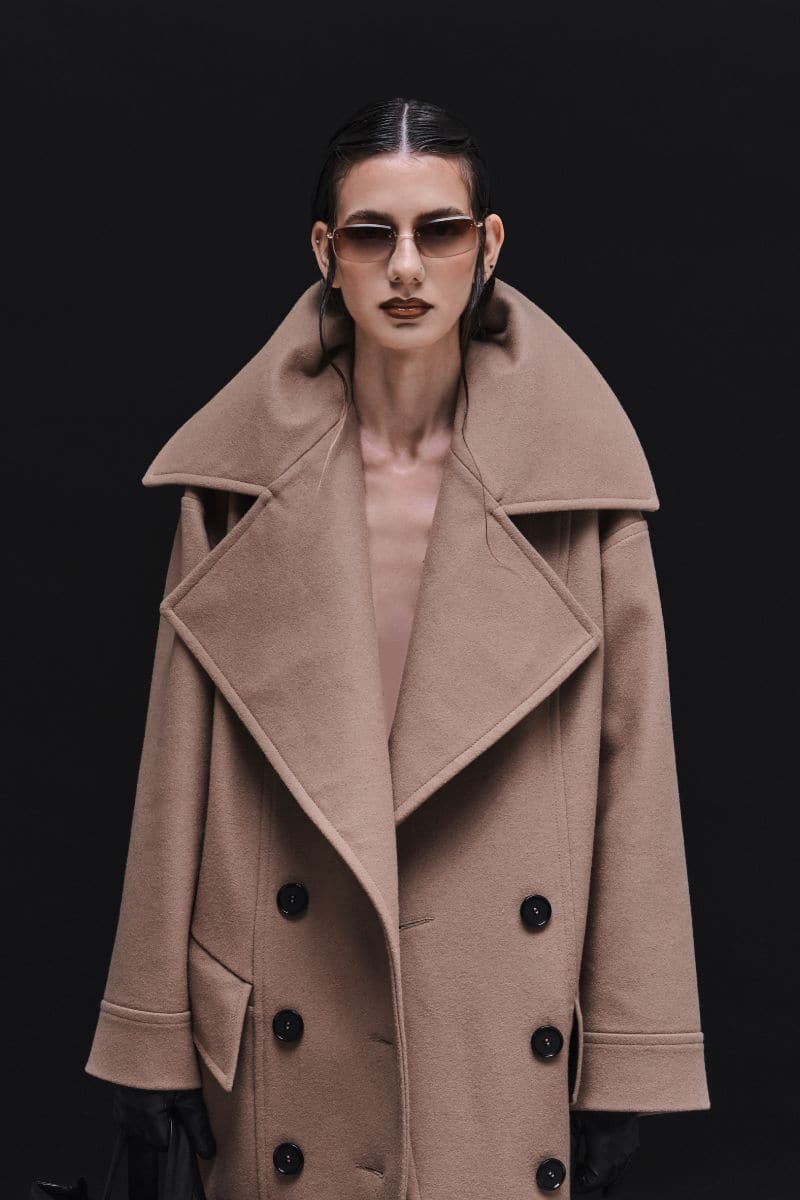 Vaska double-breasted relaxed coat in caramel color, shown on a model, with a tailored fit and classic lapel design.