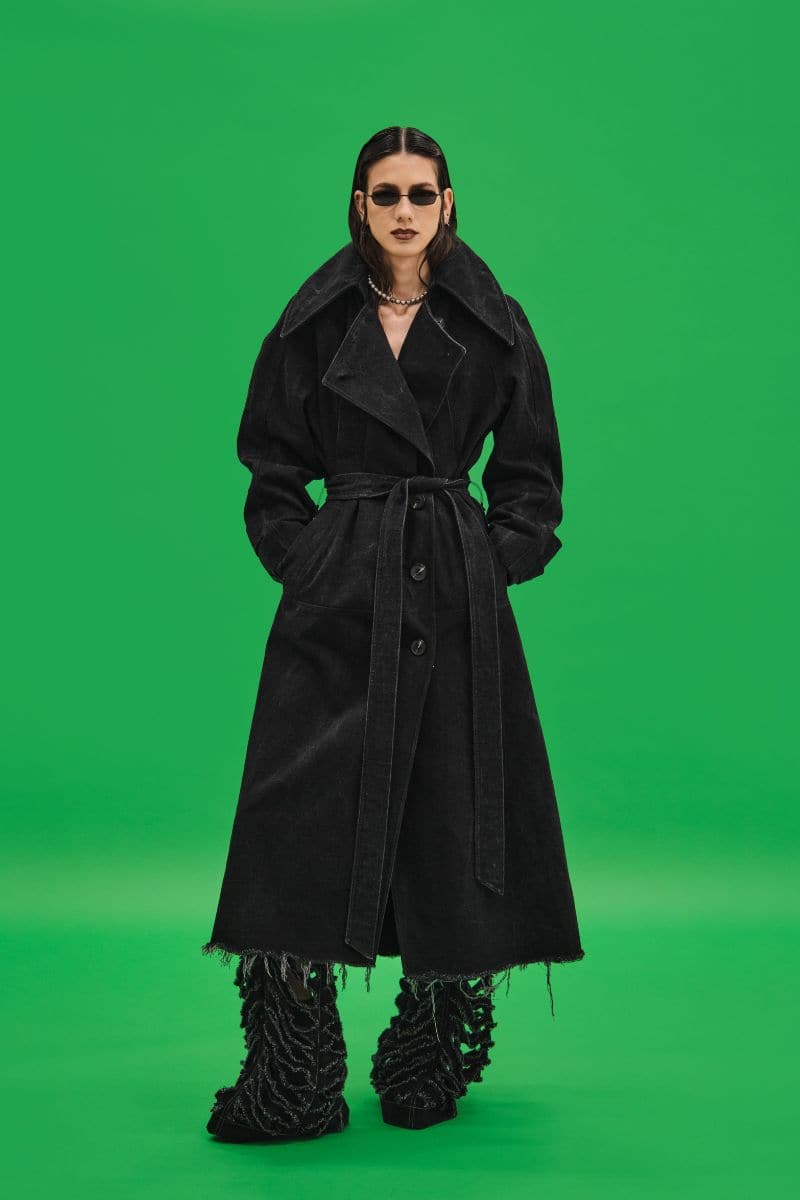 Black oversized washed denim trench coat by Vaska, showing the relaxed fit and classic design on a model.