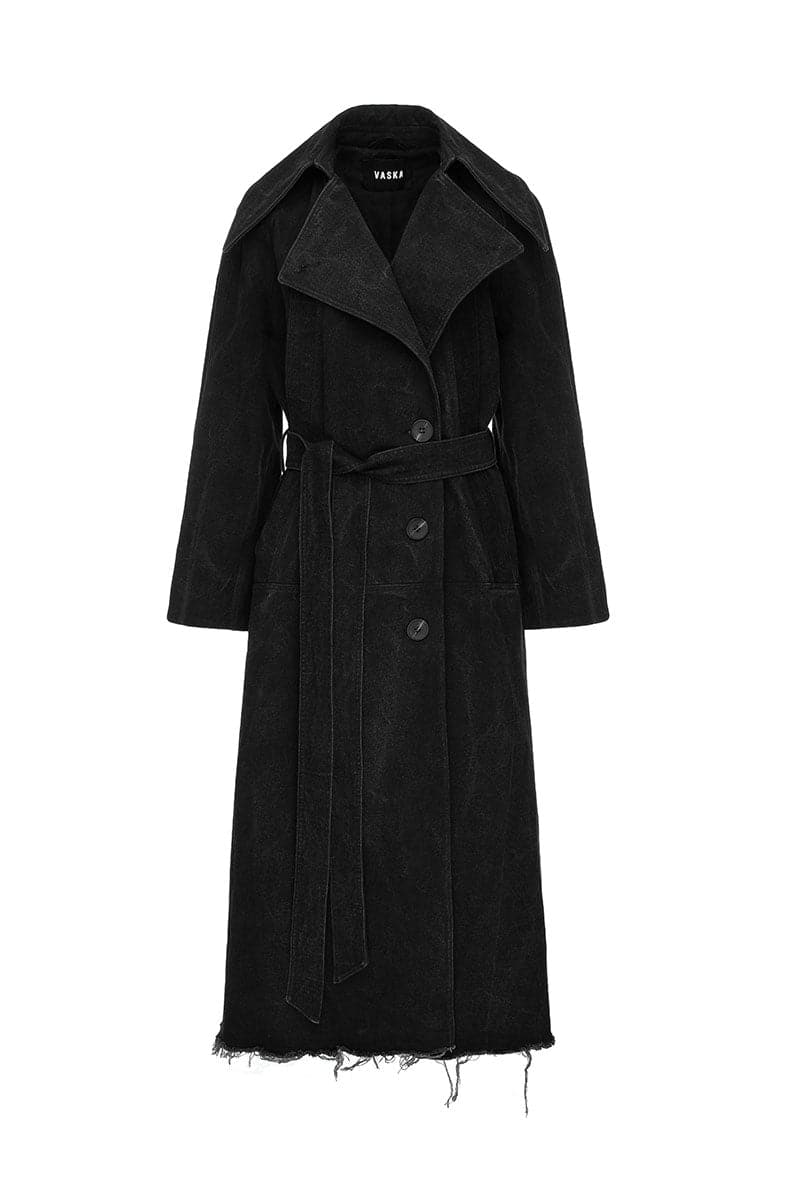 Black oversized washed denim trench coat by Vaska, showing the relaxed fit and classic design on a model.